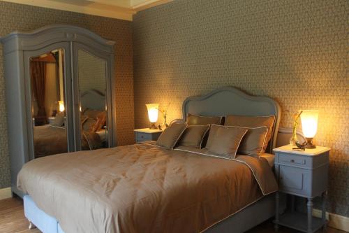 赫尔蒙德Bosgeluk的一间卧室配有一张带两盏灯和镜子的床。