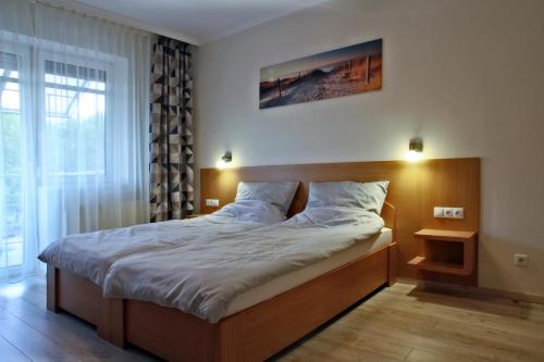 豪伊杜索博斯洛Aqua City Apartman的一间卧室配有一张大床和木制床头板