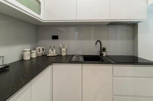 杜布罗夫尼克Apartman Roseta的厨房配有白色橱柜和黑色台面