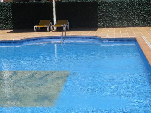 埃斯塔蒂特圣安娜酒店的一个带两把椅子的大型游泳池