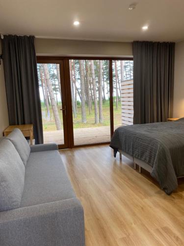 ValgerannaValgeranna puhkekeskuse hotell的一间卧室配有一张床、一张沙发和一个窗口