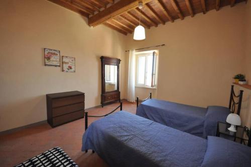 卡波利韦里Casa dei canali, sulla piazza del paese的一间卧室配有蓝色的床和梳妆台