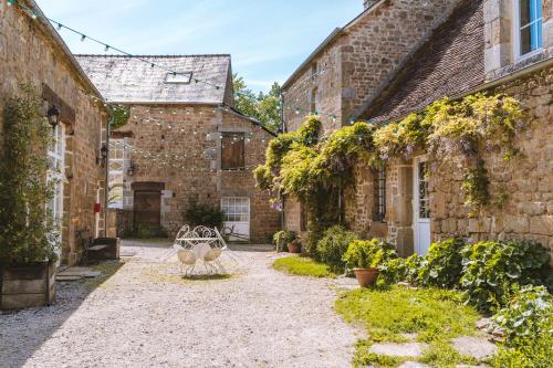 Joué-du-BoisLe gîte d'Etienne的一座带长凳的古老石头建筑的庭院