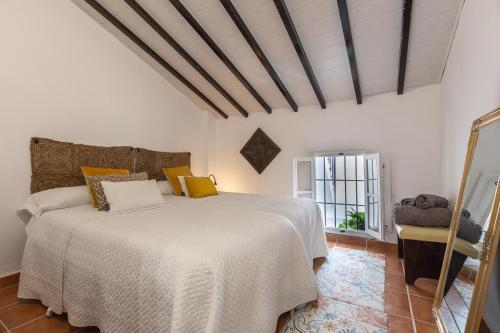 阿洛拉Casa Randonneur, traditional townhouse in Álora.的卧室配有白色的床和窗户。