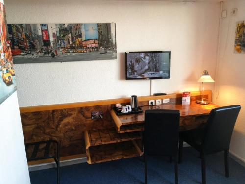 维耶尔宗艾尔驰酒店的一间设有一张桌子的房间,墙上配有电视