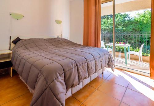 昂蒂布Orangeraie du Cap d'Antibes的一间卧室设有一张床和一个大窗户