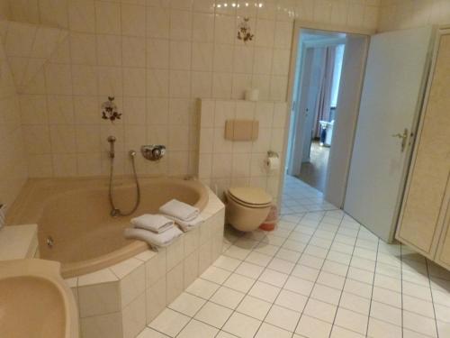 梅灵Winzergasthof zum Kellerstübchen的带浴缸、卫生间和盥洗盆的浴室