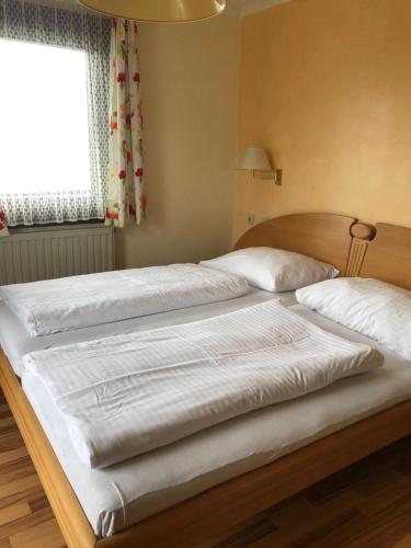 赖弗尼茨Hotel Garni Haus am Wald的卧室设有两张单人床和窗户。