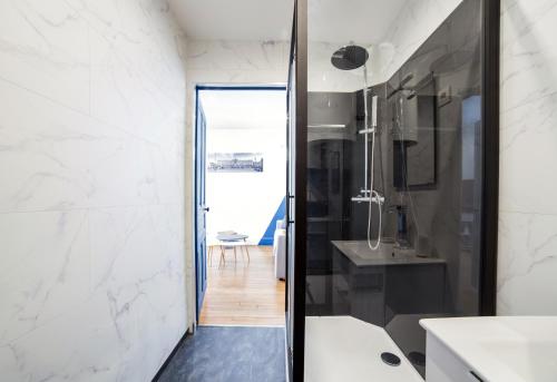 南希Appartement Le P'tit Dupont - OscarNewHome的浴室设有通往水槽的玻璃门