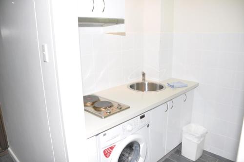 悉尼Accommodation Sydney Studio with balcony apartment的一间带水槽和洗衣机的浴室