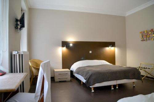 罗什福尔林堡酒店的一间卧室配有一张床、一张桌子和一张桌子。