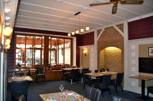 罗什福尔林堡酒店的用餐室设有桌椅和窗户。