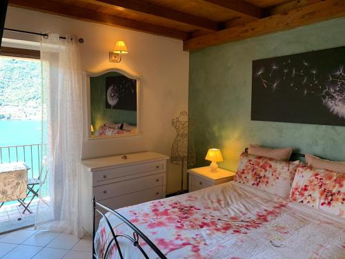 波尼亚纳拉廖La Casa del Mastro - Como Lake的一间卧室设有一张大床和一个窗户。