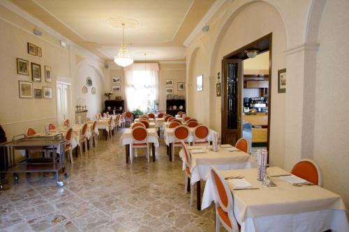 瓦雷塞利古雷阿尔伯格阿米奇酒店的餐厅内带桌椅的用餐室