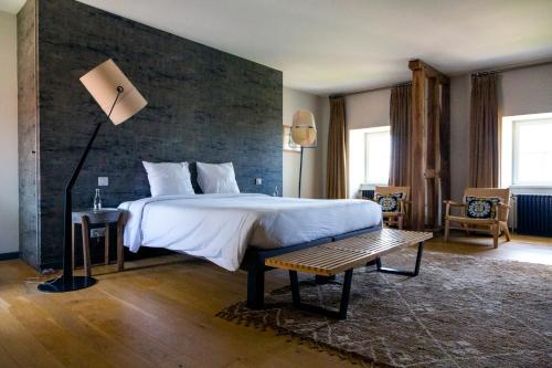 AnthenayFerme du Château的一间卧室设有一张带砖墙的大床