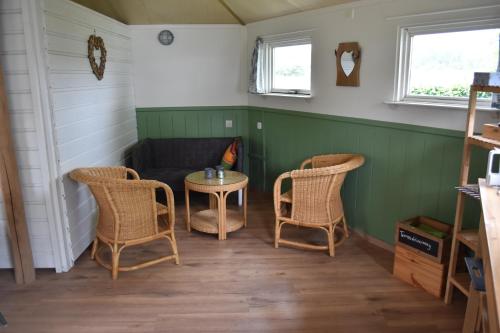 Kronenberg't Peelhuisje的一间设有两把椅子、一张桌子和一张沙发的房间