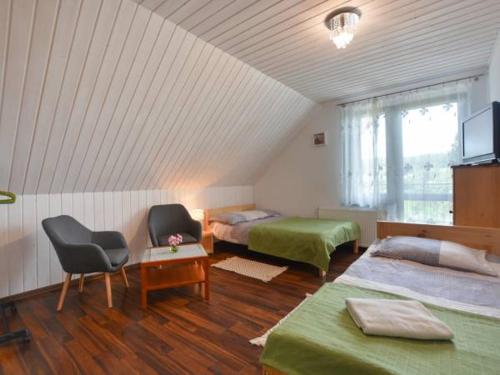 波拉齐克HarmoniaUrlopu的客房设有两张床、一把椅子和电视。