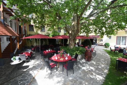 派尔巴赫Hotel Payerbacherhof的树下设有桌椅的户外餐厅