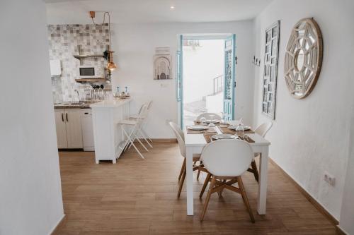 弗里希利亚纳Casa Calle Real 87的厨房以及带白色桌椅的用餐室。