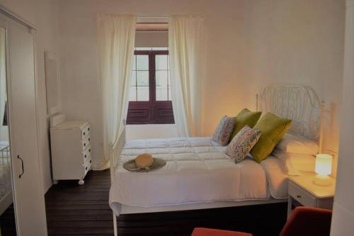ArafoLa Casa Vieja的卧室配有白色的床和帽子