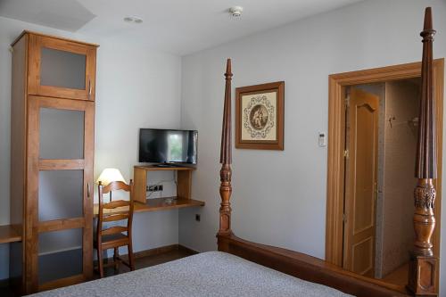 莫蒂利亚德尔帕兰卡尔塞托斯酒店餐厅的一间卧室配有一张床、一台电视和一把椅子