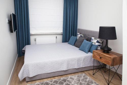 赫尔Apartament Silva View的一间卧室配有一张带蓝色窗帘和灯的床
