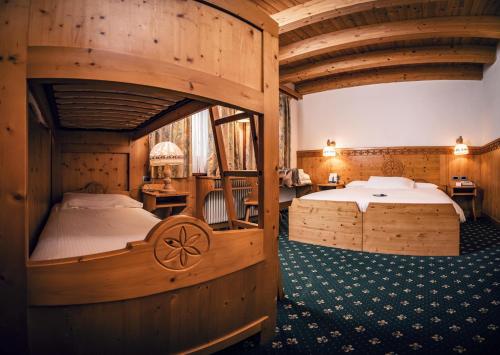布伦托尼科Hotel San Giacomo Spa&Gourmet的一间带两张床铺的卧室,位于带木墙的房间内