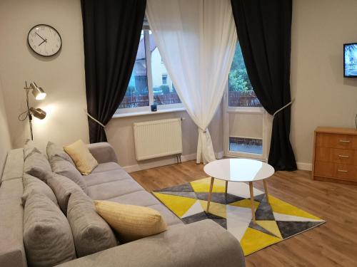 绿山城Green Yew Apartment的客厅配有沙发和桌子