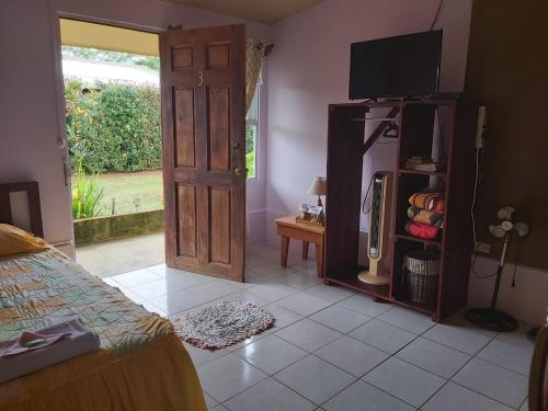 Caño NegroPosada Rural Oasis的一间卧室配有一张床,另一扇门配有电视