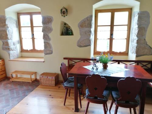 Šmarje pri JelšahHoliday house apartment Voukov mlin的一间带木桌和椅子的用餐室