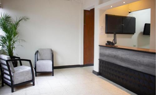 底拉斯卡拉Hotel Winn Comfort的一间配有电视和椅子的等候室