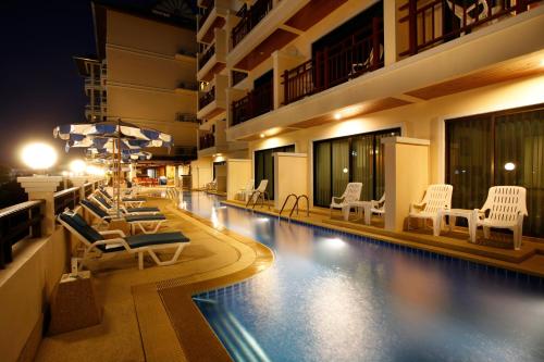 芭东海滩Jiraporn Hill Resort的酒店游泳池设有躺椅和遮阳伞