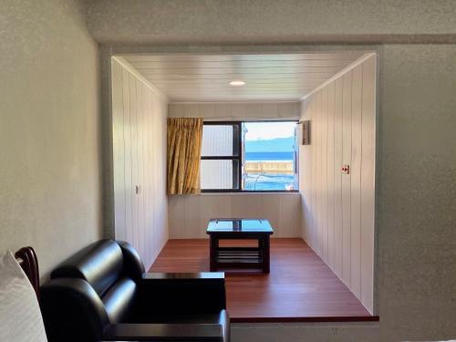 小琉球岛好事好室Goodthings的客厅配有真皮沙发和窗户