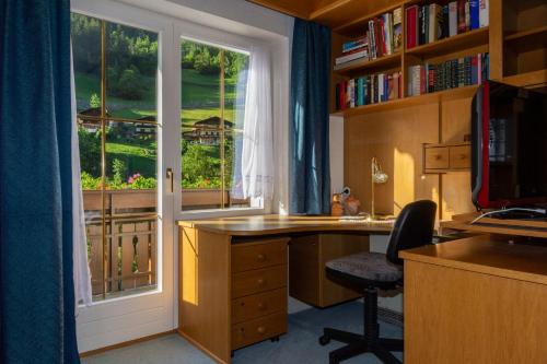 胡普加顿蒂弗雷Ferienwohnung Elfriede的一个带书桌的办公室和一个享有美景的窗户