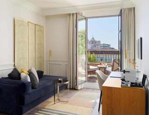巴塞罗那H10卡萨含羞草4*索普酒店的客厅设有蓝色的沙发和大窗户