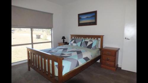 Bonnie DoonGone skiing的一间卧室设有一张木床和一个窗户。