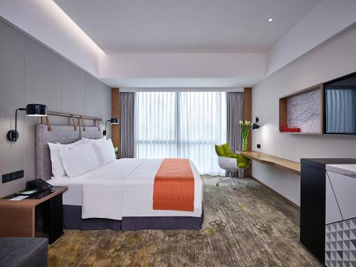 广州广州南湖假日酒店-广交会期间提供免费接驳车的酒店客房设有一张大床和一台电视。