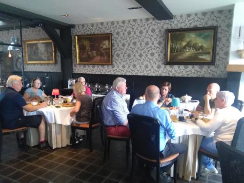 达默Gasthof Maerlant的一群坐在餐厅桌子上的人