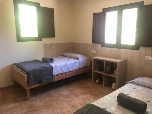 普里埃格·德·科尔多巴Casa de Campo Patricia的一间卧室设有两张床和两个窗户。