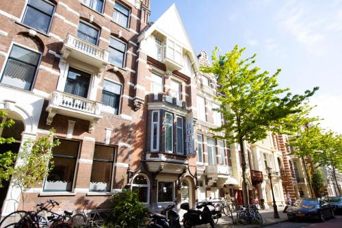 阿姆斯特丹昆汀英格兰酒店的一座建筑前面停放着自行车