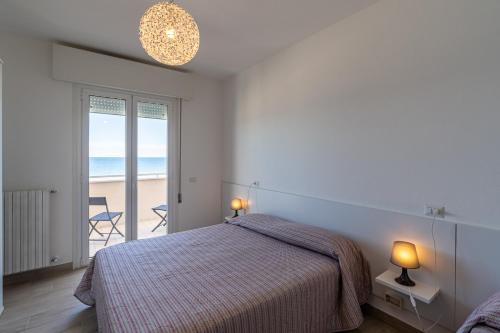 贝拉里亚-伊贾马里纳Residenza Las Vegas的一间卧室配有一张床,享有海滩美景