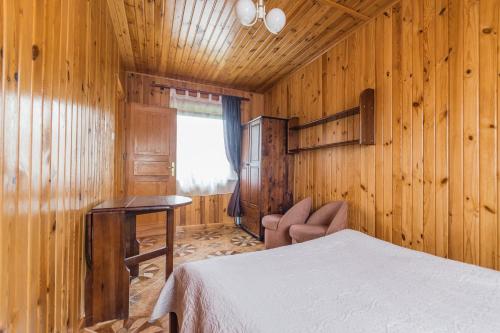 斯图托沃Stanica Przygody的卧室设有木墙、一张床和窗户