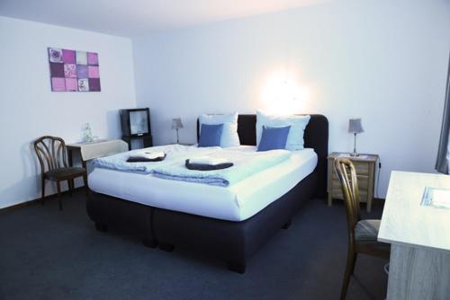 库克斯港Hotel Deutsches Haus的一间卧室配有一张带蓝色枕头的大床
