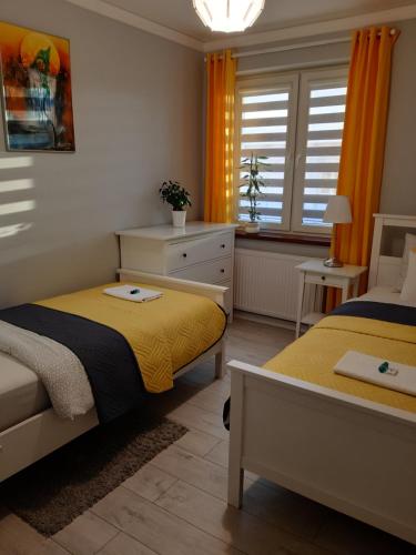 奥斯威辛Apartament FAMILY- klimatyzacja的一间卧室设有两张床和窗户。