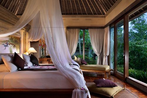 乌布皇家皮塔玛哈酒店的一间卧室配有一张带蚊帐的床