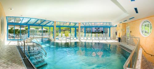 弗拉绍Hotel Vierjahreszeiten的大楼内的一个蓝色海水游泳池