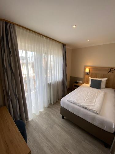 Großheubach罗森布什酒店的一间卧室设有一张床和一个大窗户