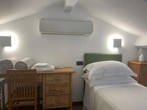 韦内雷港艾尔伯格天堂餐厅酒店的一间卧室配有一张床和一张带风扇的书桌