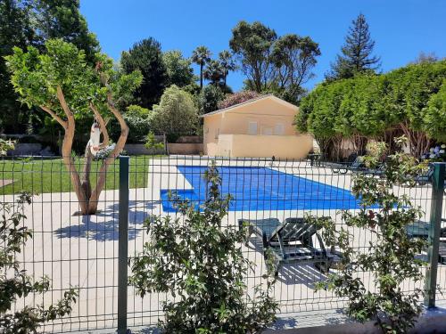 Vilar do PinheiroMetro Vilar Suites & Villas的院子中带游泳池的围栏