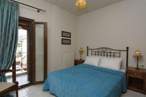 波尔塔里亚IATROU HOUSE- villa WITH INCREDIBLE VIEW的一间卧室设有蓝色的床和窗户。